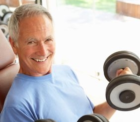 Senior Man Working With Weights In Gym